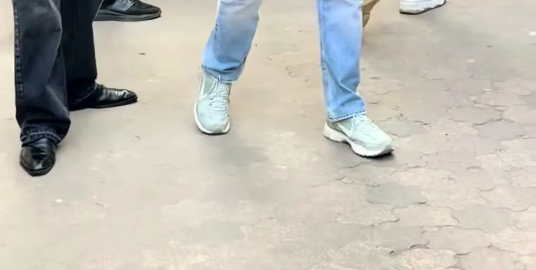 Ram Charan — The shoes: pale seafoam mesh, thick cream midsole, dark outsole edge, and the jeans stacking over them