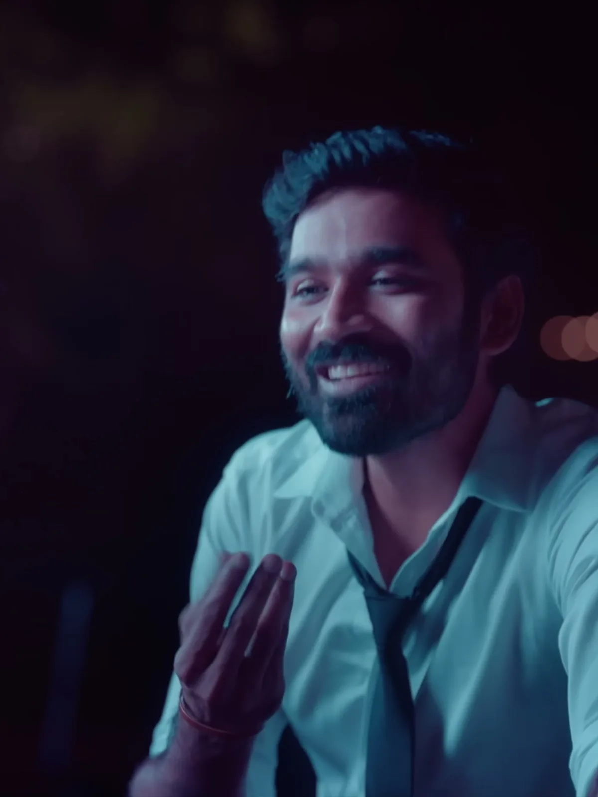 The Megham Karukatha white shirt and loose black tie — Dhanush