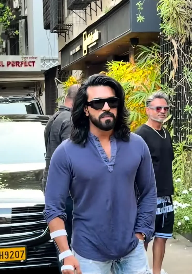 Ram Charan — The fit together — slate-blue shirt worn untucked over the bleached straight jeans