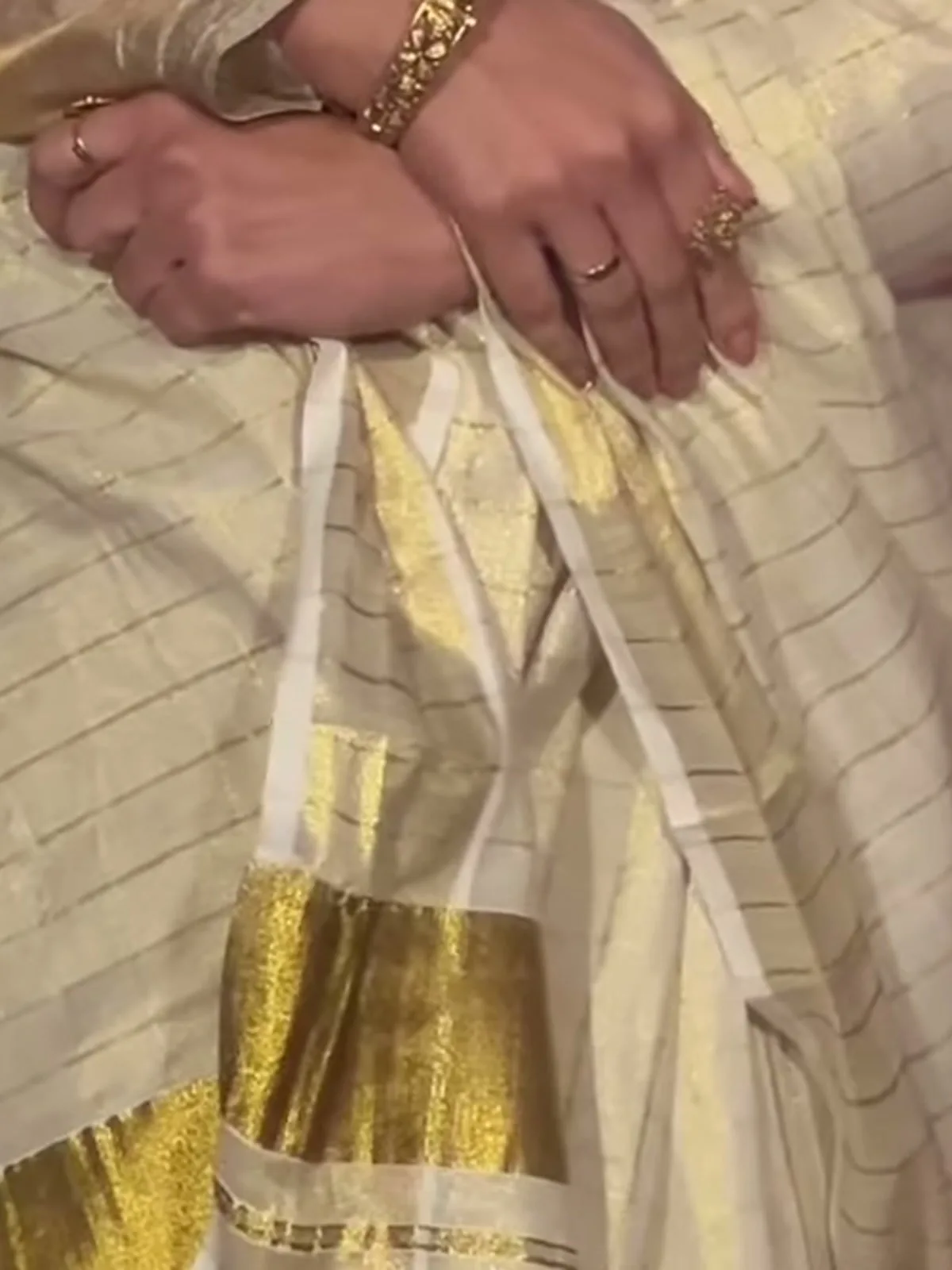Genelia D’Souza — The weave up close — a fine gold-zari windowpane check on ivory tissue, and the broad flat gold kasavu border below it