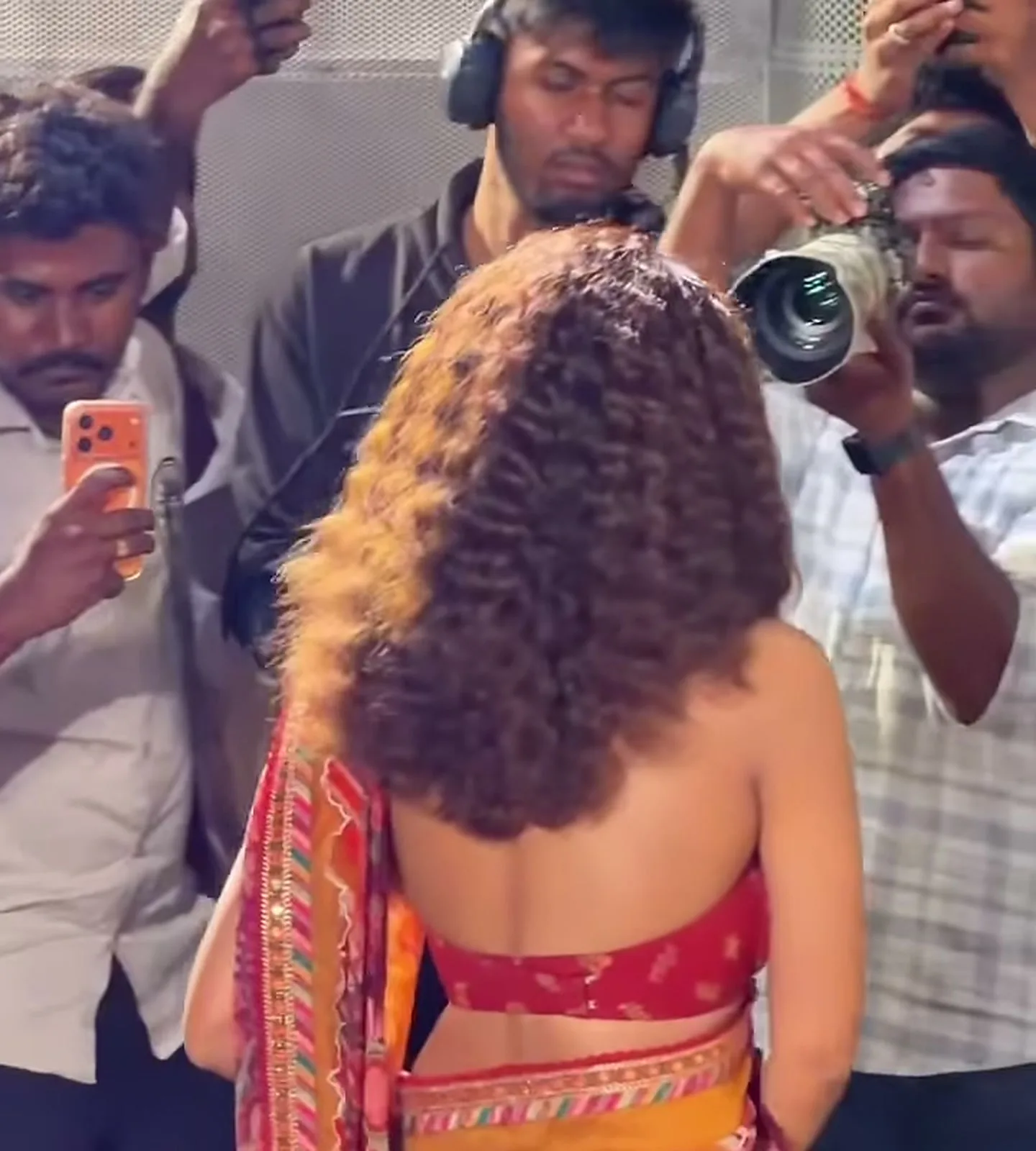 Anupama Parameswaran — From behind — the blouse is open but for one wide band, and the mustard belt sits over the drape