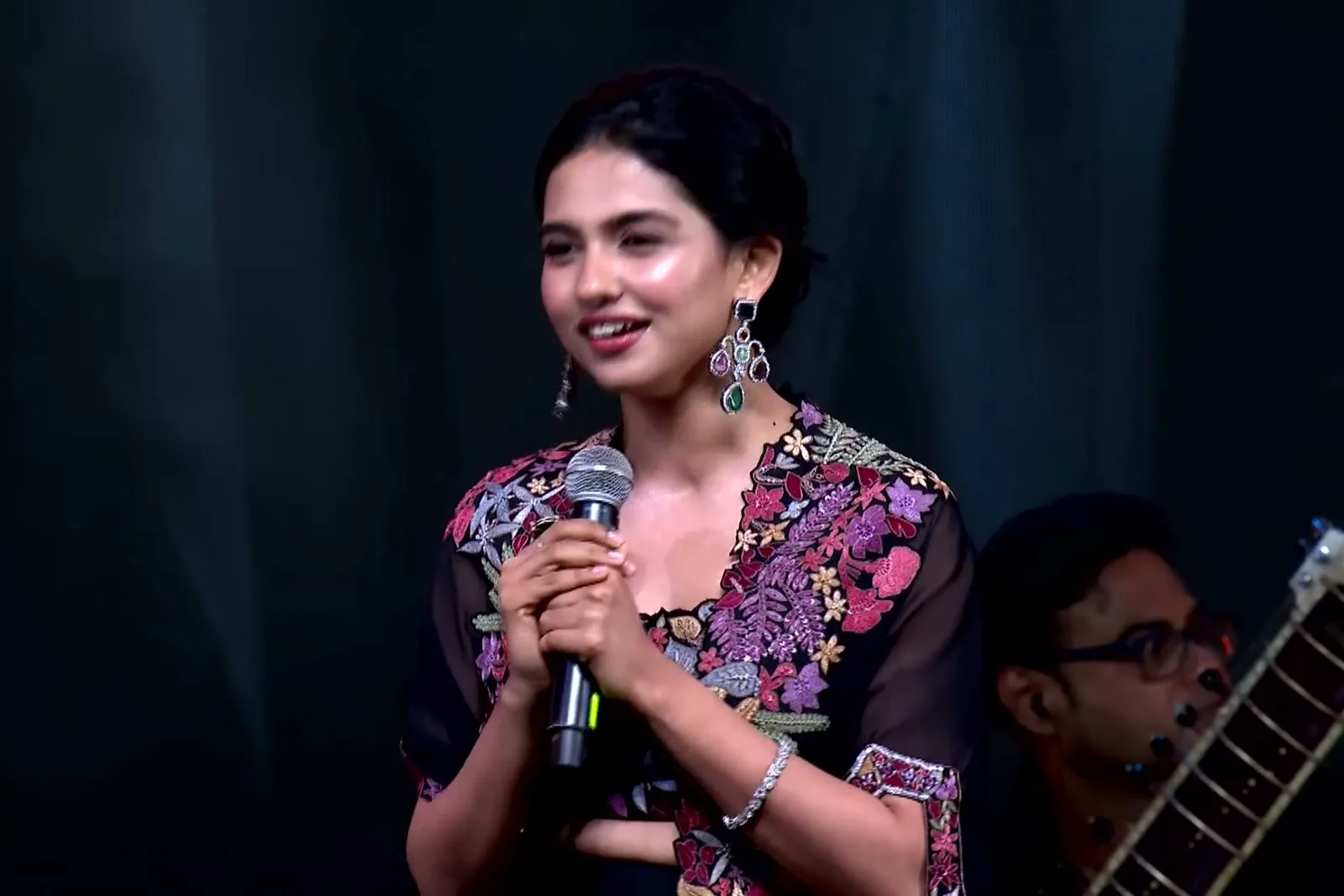 Mamitha Baiju — Speaking — the cape hangs open with nothing holding it closed