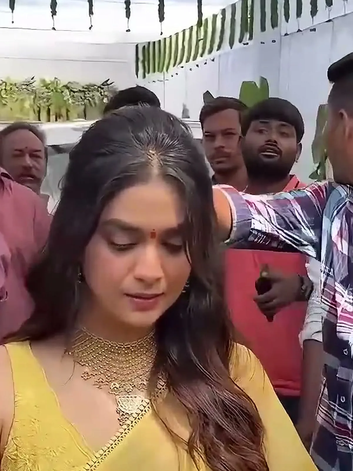Keerthy Suresh — Walking in, in warm daylight: the same collar reads gold rather than silver the moment the light changes