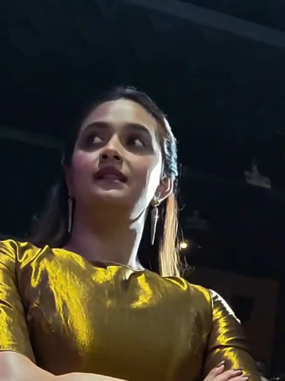 Keerthy Suresh — Seated, arms crossed — the molten gold twill and the elbow-length sleeve