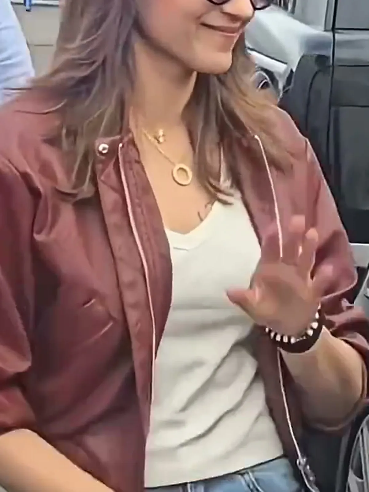 Trisha Krishnan — Close on the front edge: the pink piping, the dome snap, and the shallow V of the ribbed tee