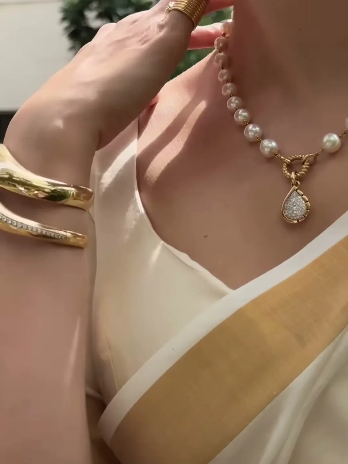 Tamannaah Bhatia — The two Wave bangles stacked on her right wrist — polished gold over the diamond-channel one