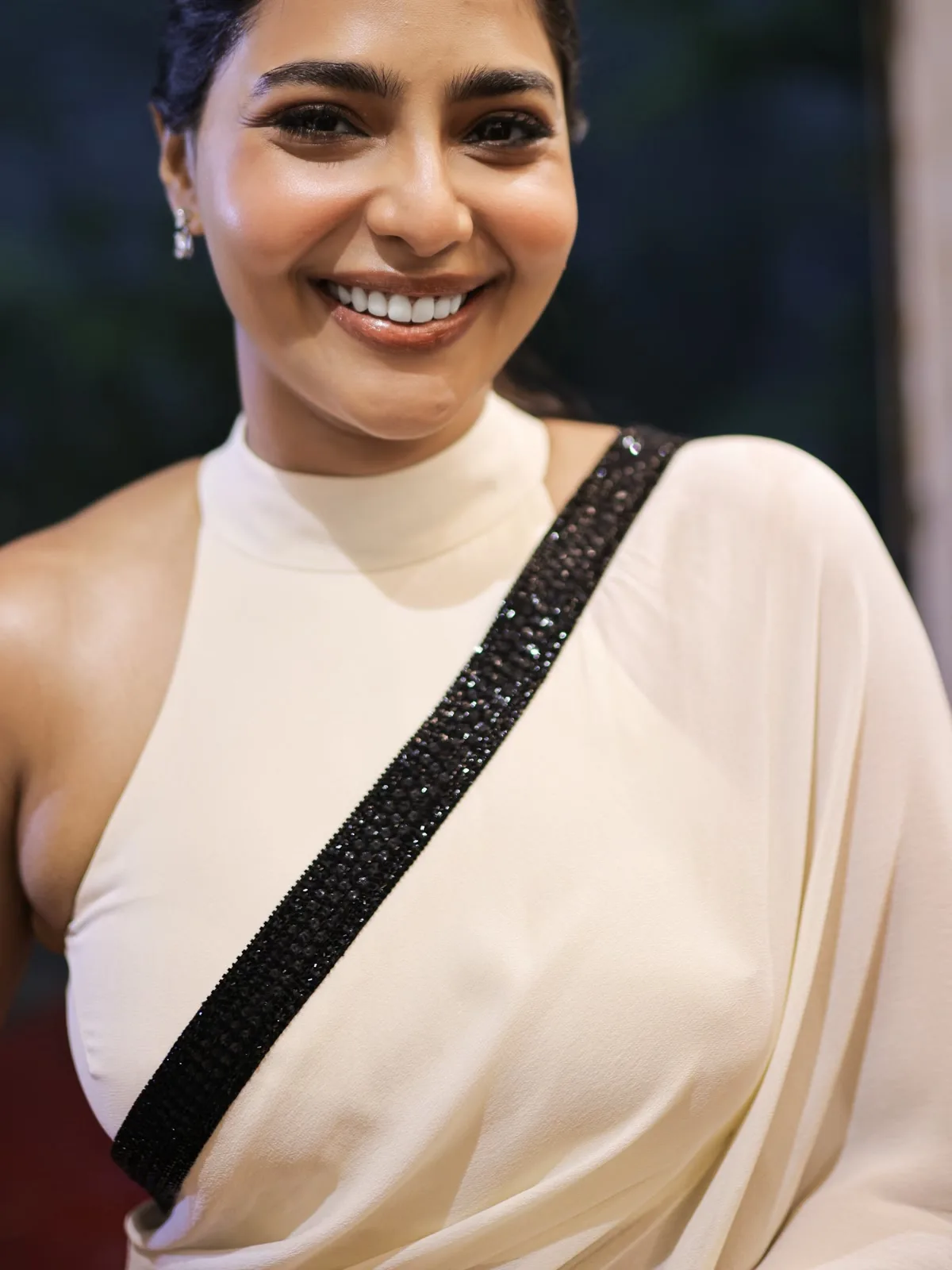 Aishwarya Lekshmi — Close on the border: faceted black beads in dense rows with a looped picot fringe, not sequins and not print. And the soft fold at the top of the collar