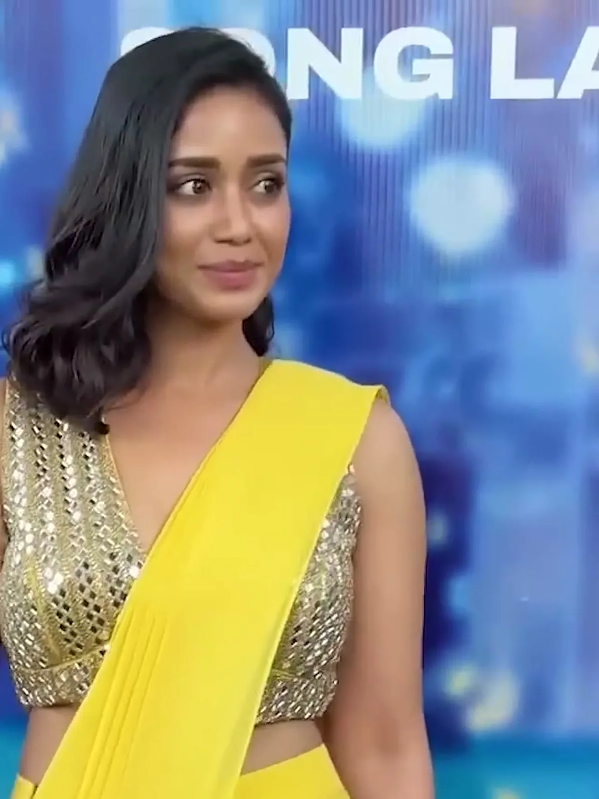 Nivetha Pethuraj — On stage in front of the song-launch backdrop