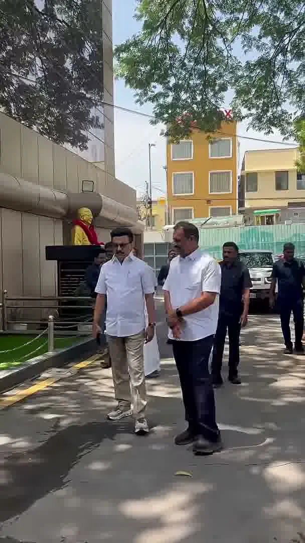 Vijay — Mid-stride outdoors, with others in the same white-shirt-and-chinos styling