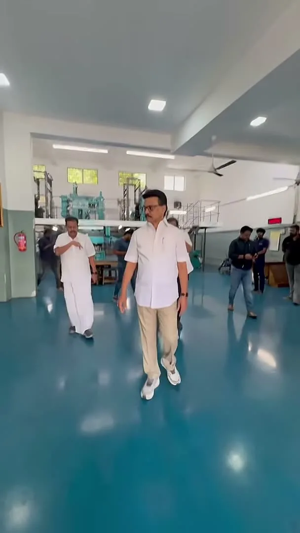 Vijay — Walking away — the shirt untucked at the back hem, plain khaki through the leg
