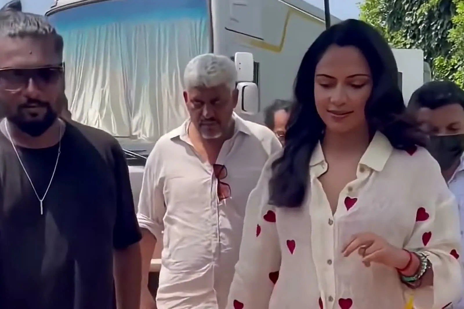 Amala Paul — Walking in with the unit — the shirt reads oatmeal, not white, against their whites