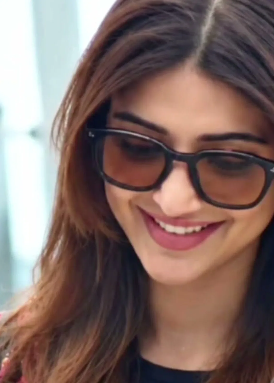 Sreeleela — At the airport: the brown-lens sunglasses, the black top and the striped hood around her shoulders