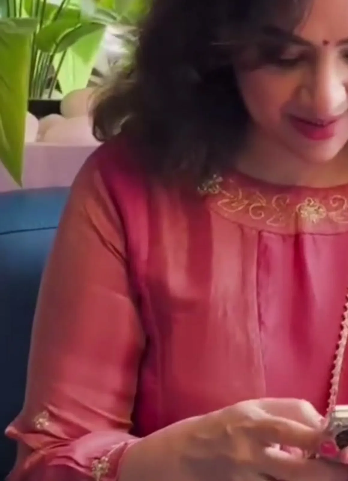 Meena — Seated: the floral butas and scrolled cuff on the three-quarter sleeve