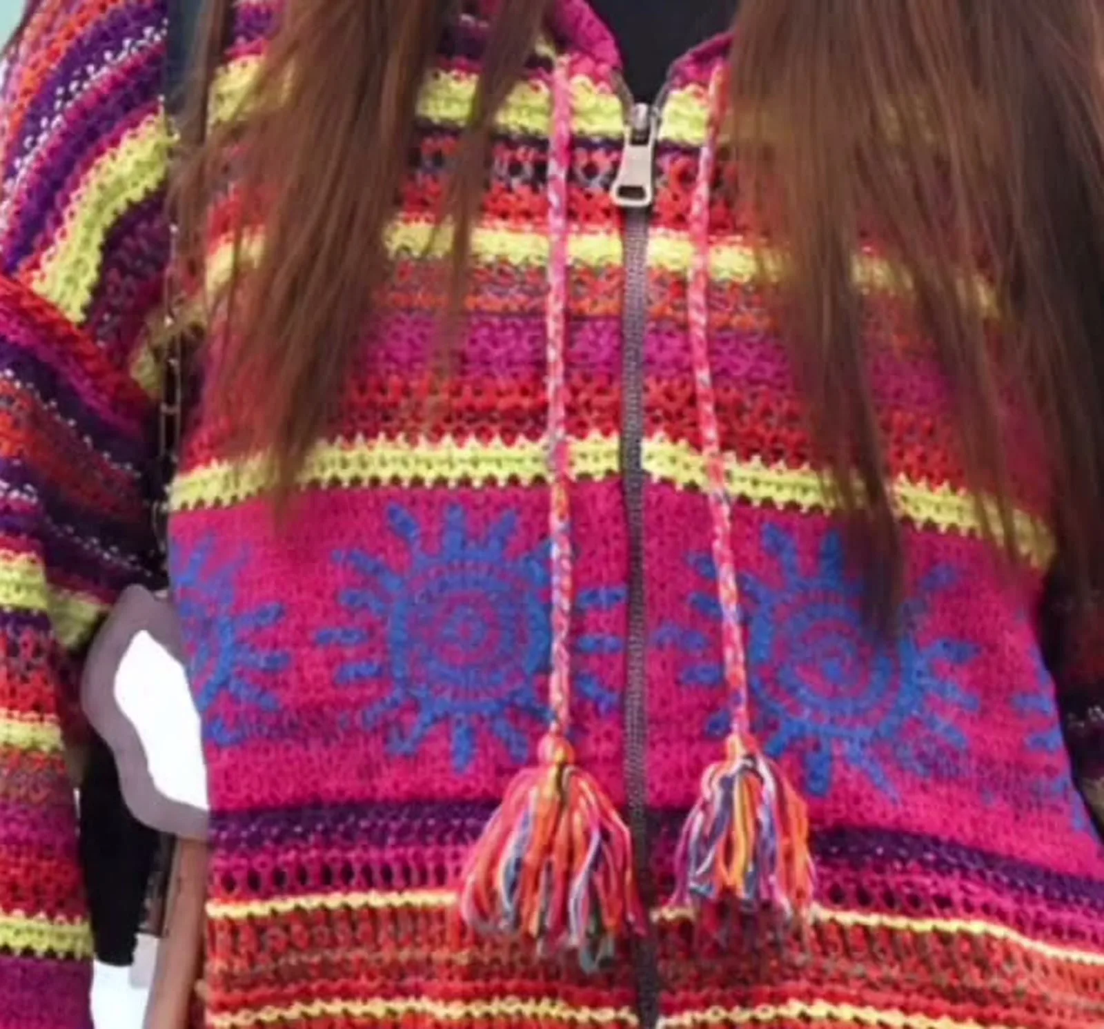 Sreeleela — Close on the knit: the open crochet stripes, the sun-motif band and the braided drawstrings